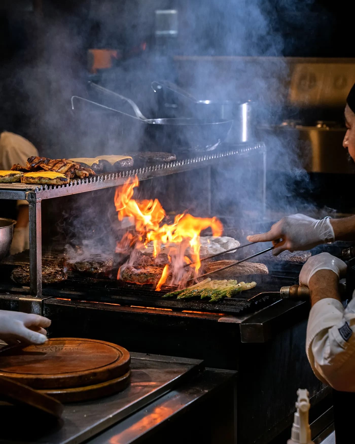 Chefs trabalhando na grelha de uma cozinha profissional
